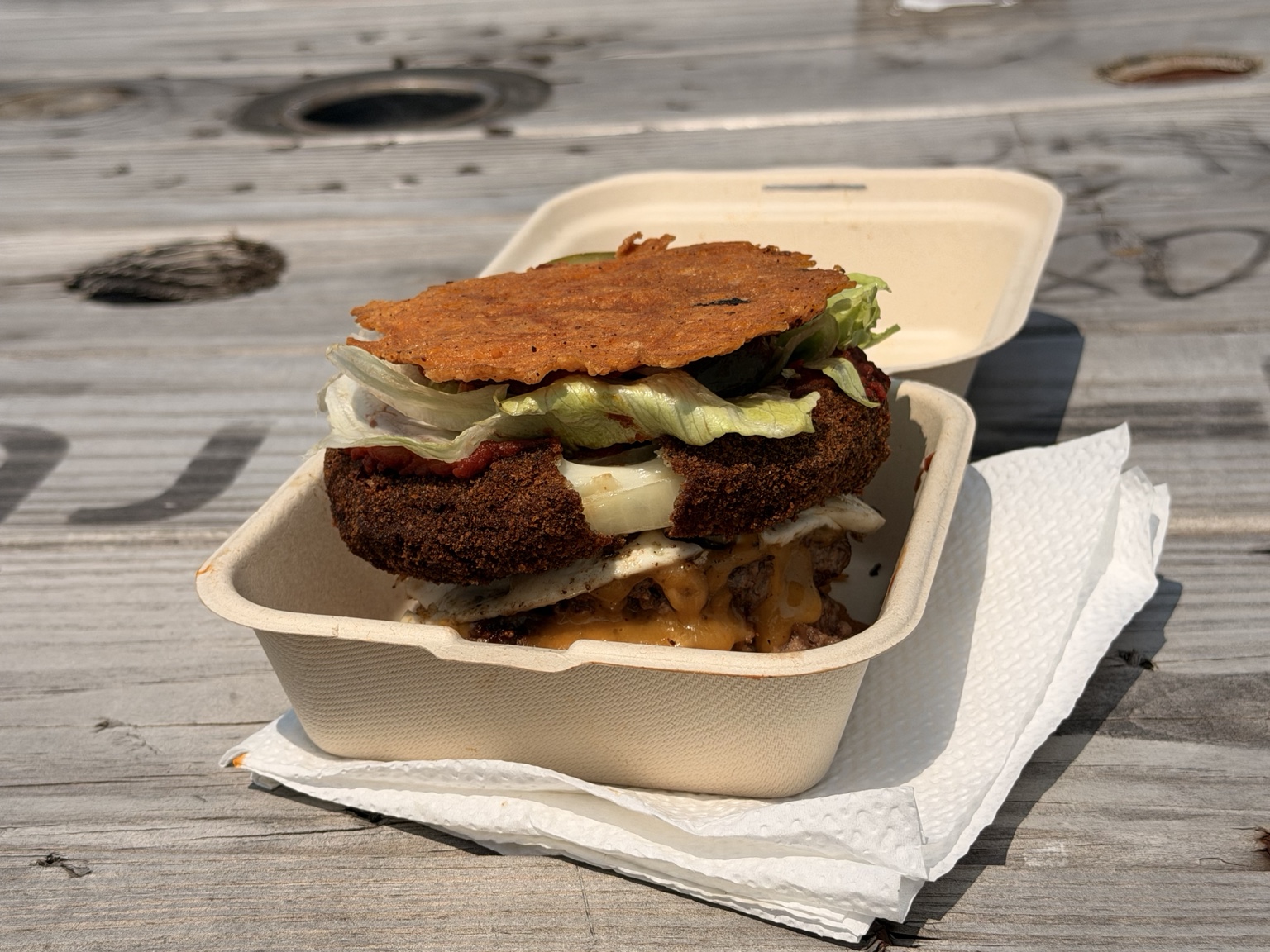 Sear N Sizzle burger on a signature cheese bun in a takeout box
